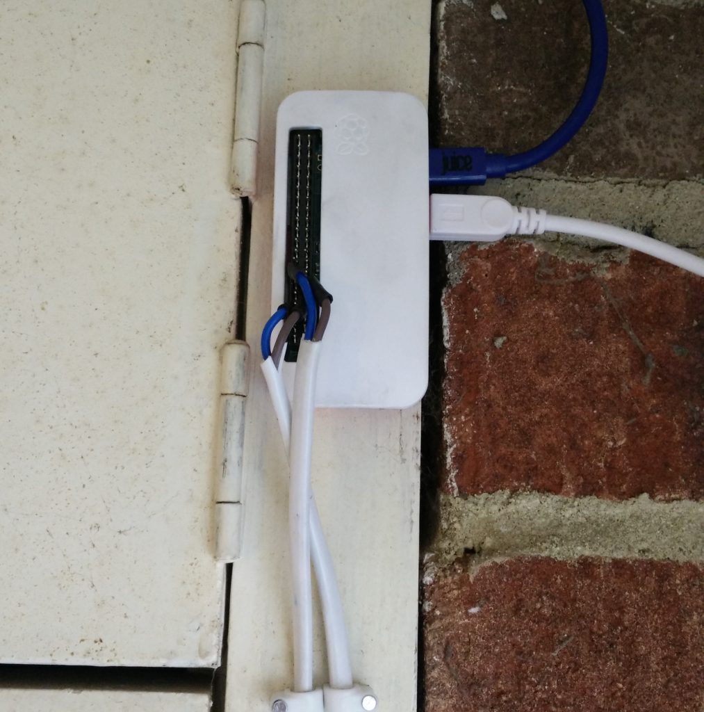 Rasberry Pi Zero mounted on wall with USB cables and GPIO connectors